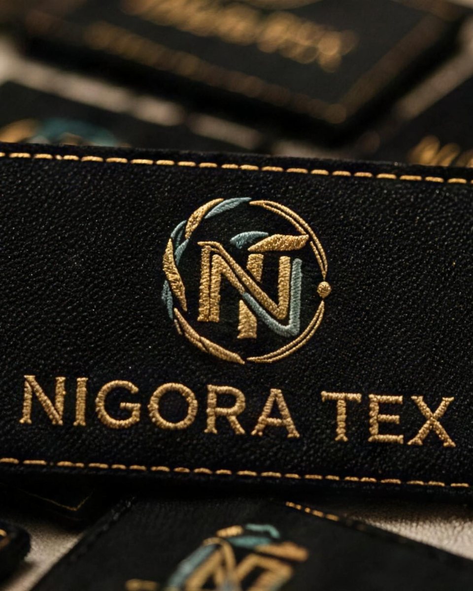NIGORATEX jakard to‘qilgan etiketka — kashtalangan logotip bilan